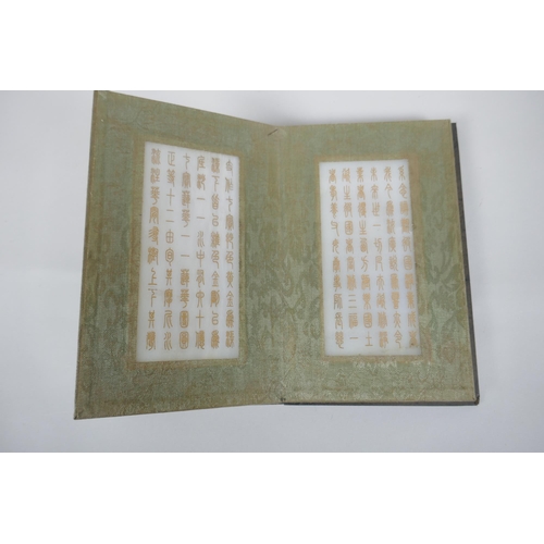 40 - A Chinese wood and silk bound book containing white jade tablet pages with chased and gilt inscripti... 