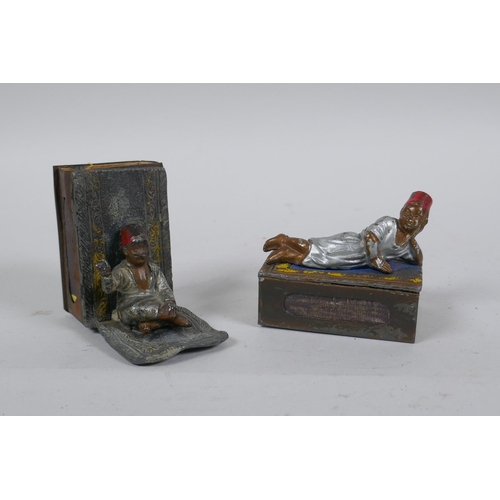 47 - A pair of antique cold painted metal matchbox holders decorated with Arab boys on carpets, in the ma... 