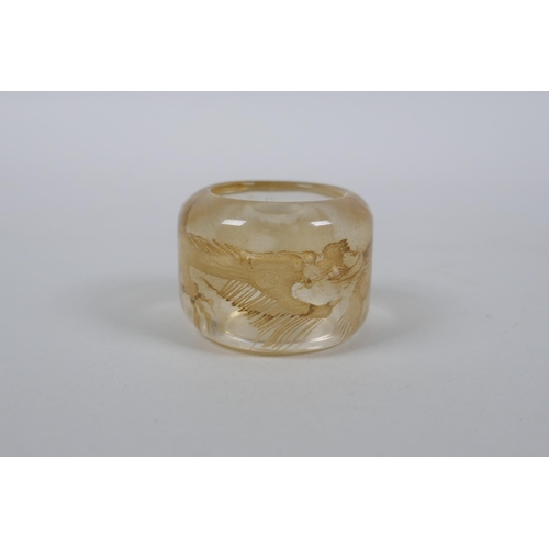 59 - A Chinese rock crystal archers thumb ring with dragon decoration, 3cm diameter