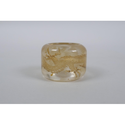 59 - A Chinese rock crystal archers thumb ring with dragon decoration, 3cm diameter