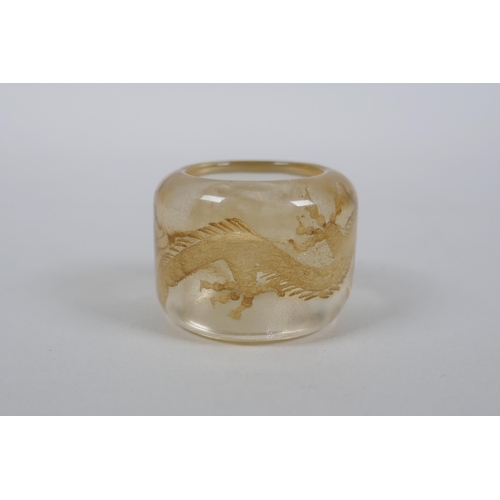 59 - A Chinese rock crystal archers thumb ring with dragon decoration, 3cm diameter