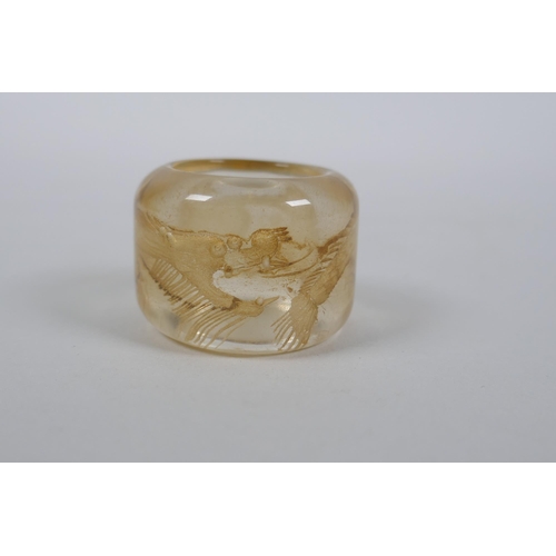 59 - A Chinese rock crystal archers thumb ring with dragon decoration, 3cm diameter