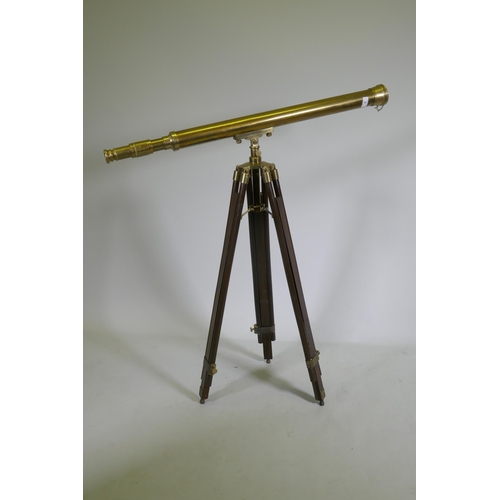 6 - A brass telescope on telescopic wood stand, 98cm long, 104cm high