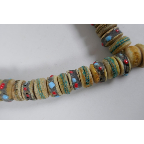 617 - A Tibetan string of stone set bone mala beads, including turquoise, bone, nut, stone etc