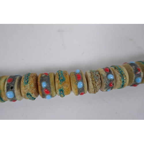 617 - A Tibetan string of stone set bone mala beads, including turquoise, bone, nut, stone etc