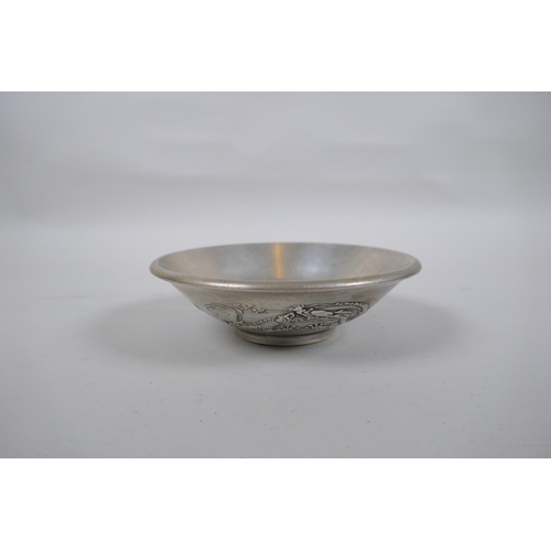 629 - A Chinese white metal dish with raised phoenix and dragon decoration, character mark to base, 14cm d... 