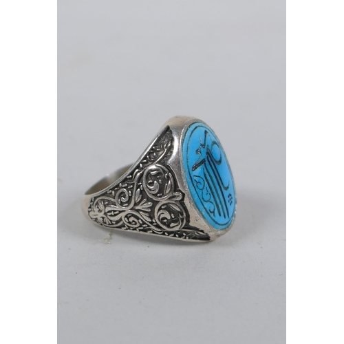 632 - An Islamic white metal ring set with a turquoise intaglio seal, size Q/R