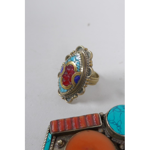 636 - A collection of Tibetan coral and turquoise set gilt metal pendants and rings