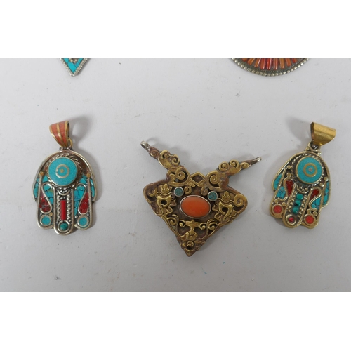 636 - A collection of Tibetan coral and turquoise set gilt metal pendants and rings