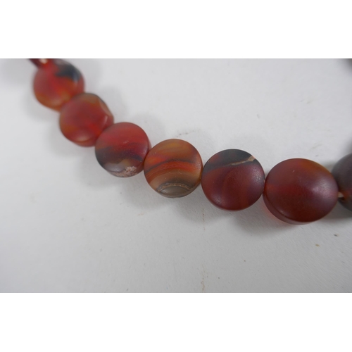 638 - A string of graduated turquoise beads, together with a string of amber agate beads