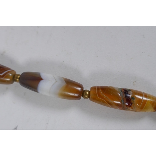 642 - A string of graduated banded agate beads, 66cm long