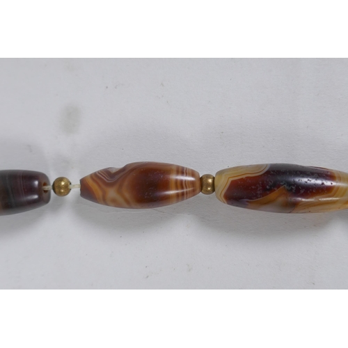 642 - A string of graduated banded agate beads, 66cm long