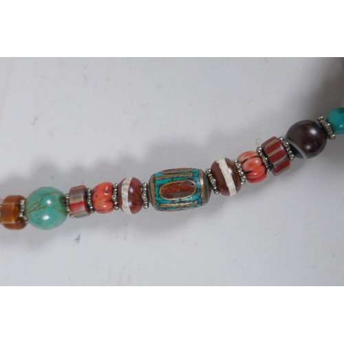 644 - A Tibetan coral, turquoise, banded agate and glass bead necklace with enamelled white metal feature ... 