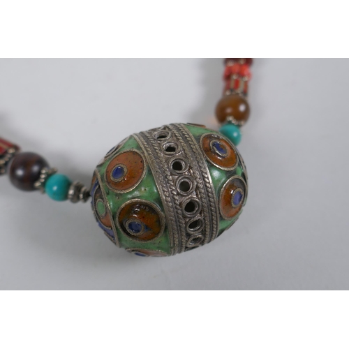 644 - A Tibetan coral, turquoise, banded agate and glass bead necklace with enamelled white metal feature ... 