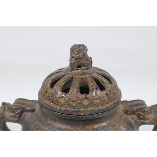 74 - A Chinese gilt bronze censer and pierced cover, raised on tripod supports, with two dragon mask hand... 