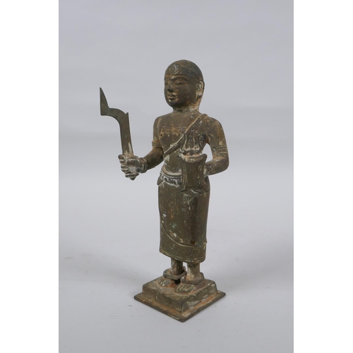 9 - An antique South Indian bronze figure carrying Theyyam sword and shield, 19cm high