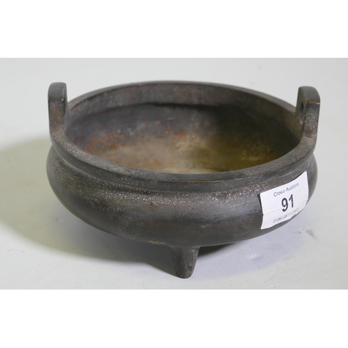 91 - A Chinese bronze censer with two handles and seal mark to base, 15cm diameter