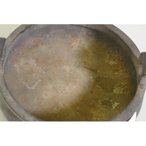 91 - A Chinese bronze censer with two handles and seal mark to base, 15cm diameter