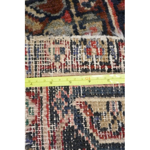 1174 - An antique Persian red and cream ground Heriz full pile carpet with black borders, 210 x 296cm