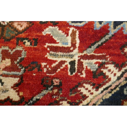 1174 - An antique Persian red and cream ground Heriz full pile carpet with black borders, 210 x 296cm