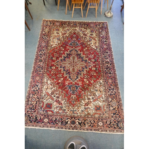 1174 - An antique Persian red and cream ground Heriz full pile carpet with black borders, 210 x 296cm