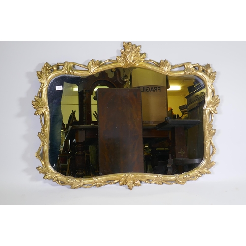 1157 - A carved and gilded pine wall mirror with oak and acorn decoration, early C20th, 114 x 92cm