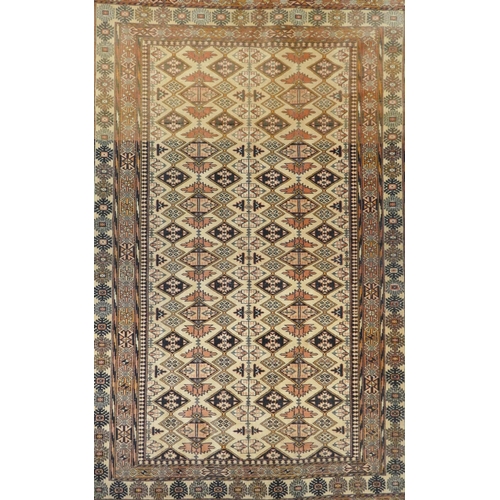 1132 - An Afghan faded red and black ground wool rug with Bokhara style design, 128 x 186cm