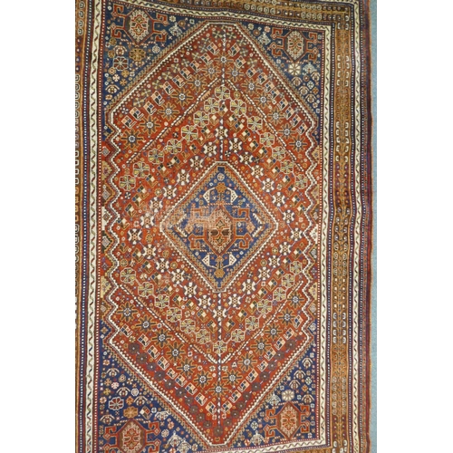 1127 - A Persian red ground wool Ghashghai carpet with unique medallion design, 172 x 260cm