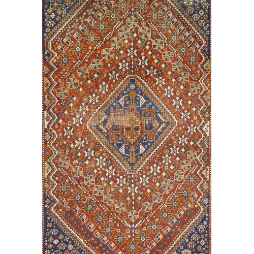 1127 - A Persian red ground wool Ghashghai carpet with unique medallion design, 172 x 260cm