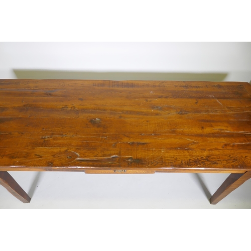 1136 - A French style oak farmhouse table with single drawer and cleated plank top, raised on square taperi... 