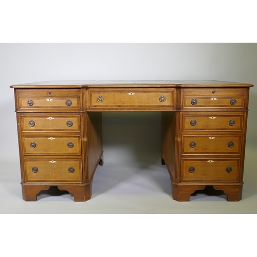 1002 - A Georgian style inlaid mahogany and yew wood pedestal partner's desk, the inverted breakfront top w... 