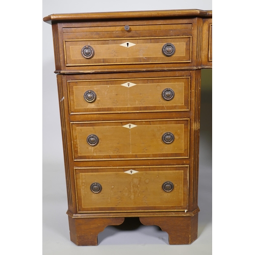 1002 - A Georgian style inlaid mahogany and yew wood pedestal partner's desk, the inverted breakfront top w... 