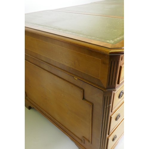 1002 - A Georgian style inlaid mahogany and yew wood pedestal partner's desk, the inverted breakfront top w... 