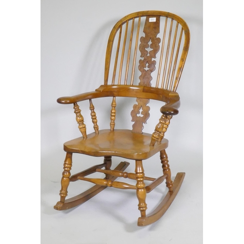 1011 - A yew wood hoopback rocking chair with pierced splat and elm seat