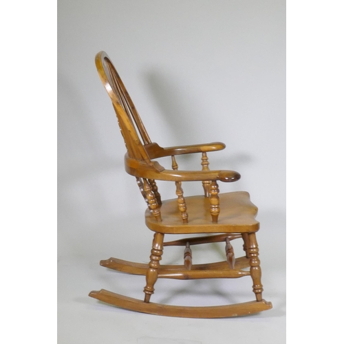 1011 - A yew wood hoopback rocking chair with pierced splat and elm seat