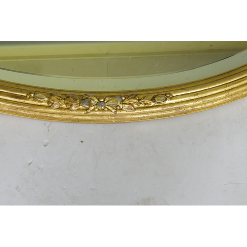 1048 - A gilt oval mirror with bevelled glass, AF losses, 82 x 60cm