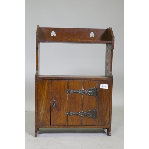 1054 - An Arts and Crafts oak cabinet with pierced decoration and metal mounts, 38 x 17 x 55cm