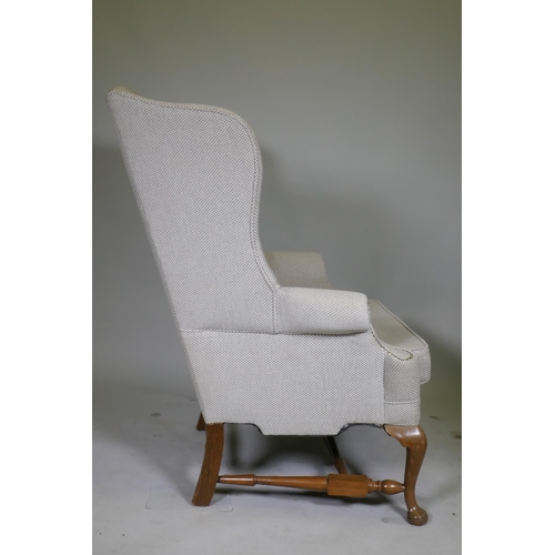 1057 - A good pair of Georgian style high back wing armchairs with wide seats, raised on walnut cabriole su... 