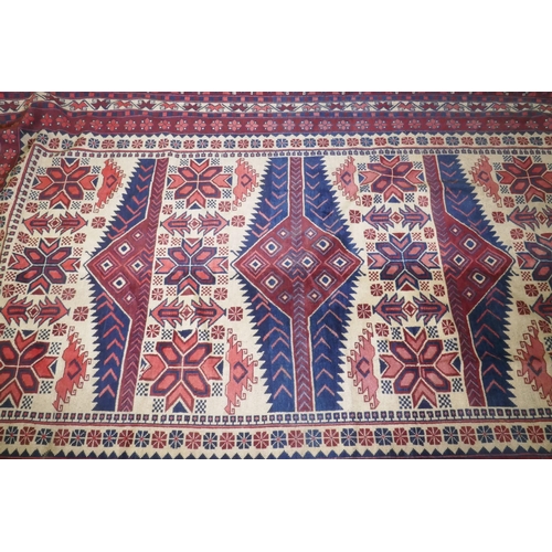 1061 - A Caucasian Kazak wool carpet with geometric designs on a red field, 200 x 300cm