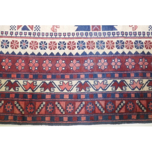 1061 - A Caucasian Kazak wool carpet with geometric designs on a red field, 200 x 300cm