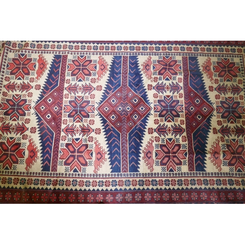 1061 - A Caucasian Kazak wool carpet with geometric designs on a red field, 200 x 300cm