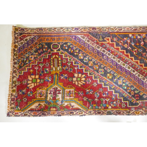 1065 - A Kashkai wool runner with geometric designs on a red field, 84 x 174