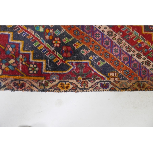 1065 - A Kashkai wool runner with geometric designs on a red field, 84 x 174