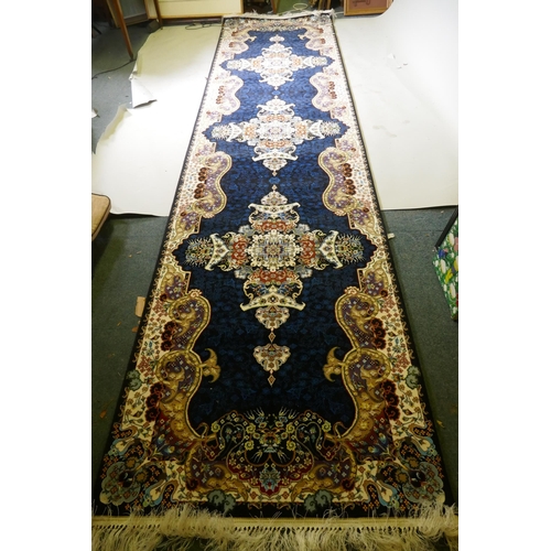 1066 - An Iranian fine woven runner with floral medallion design on a deep blue field, 100x  410cm