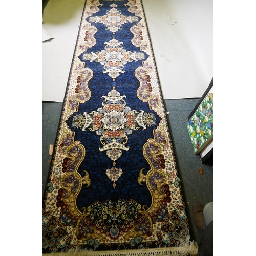 1066 - An Iranian fine woven runner with floral medallion design on a deep blue field, 100x  410cm