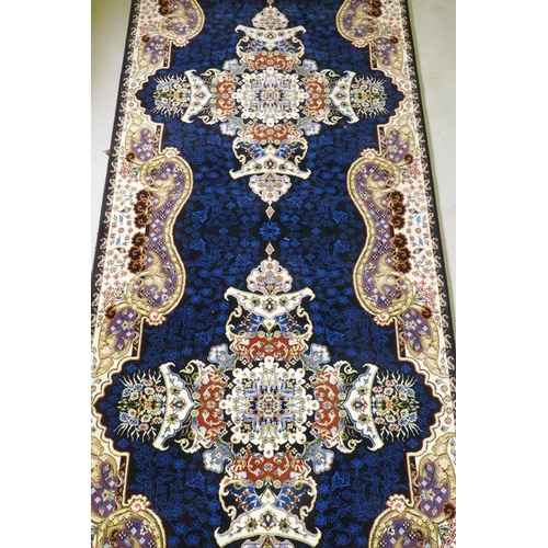 1066 - An Iranian fine woven runner with floral medallion design on a deep blue field, 100x  410cm