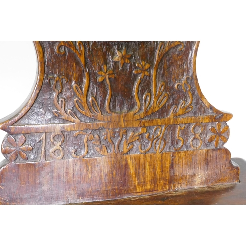 1069 - A C19th continental walnut hall chair with carved back, dated 1858 and initialled