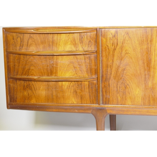 1073 - A mid century A.H. McIntosh & Co Ltd rosewood sideboard, with two cupboards flanked by three dra... 