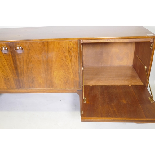 1073 - A mid century A.H. McIntosh & Co Ltd rosewood sideboard, with two cupboards flanked by three dra... 