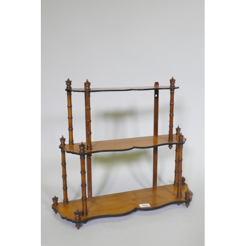 1075 - A C19th satinwood hanging wall shelf with thee shaped tiers united by faux bamboo turned supports